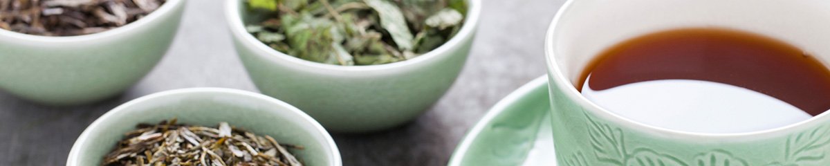 Tea leaves, next to a cup of tea
